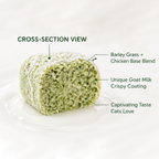 Cross-section view of a Golden Bowl Hairball Support treat showing its layered structure. The inside is a blend of barley grass and chicken, surrounded by a crispy goat milk coating. This combination delivers plant fibre for hairball relief in a taste and texture that cats actually enjoy.
